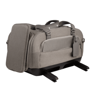 three-quarter view of compact, gray pet car seat with two carry handles on top featuring attached side impact protection, extended ISOFIX latches, and gray luggage tag - view 3