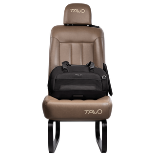 Side view of compact, black pet car seat with two carry handles on top attached to a brown vehicle seat with attached side impact protection  - view 5