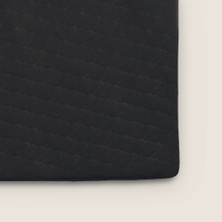 A close up image of the Everett's durable mattress pad with machine washable cover