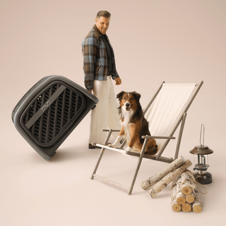 A man rolling the Everett pet cargo crate but its smooth rolling wheels and using its built in retractable magnetic handle 